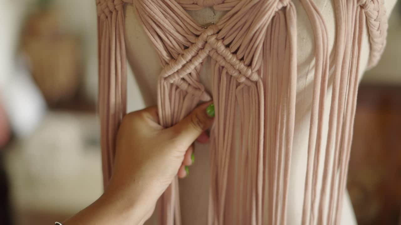 Close-up of hands crafting a macrame piece