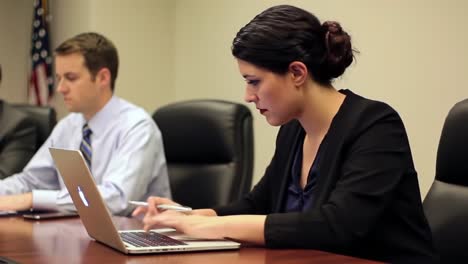 focused professional engaged in work during meeting at conference table with colleague, highlighting productivity in modern business environment