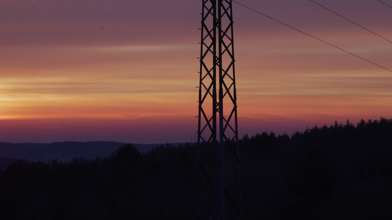 Medium shot of an electricity pylon at sunrise