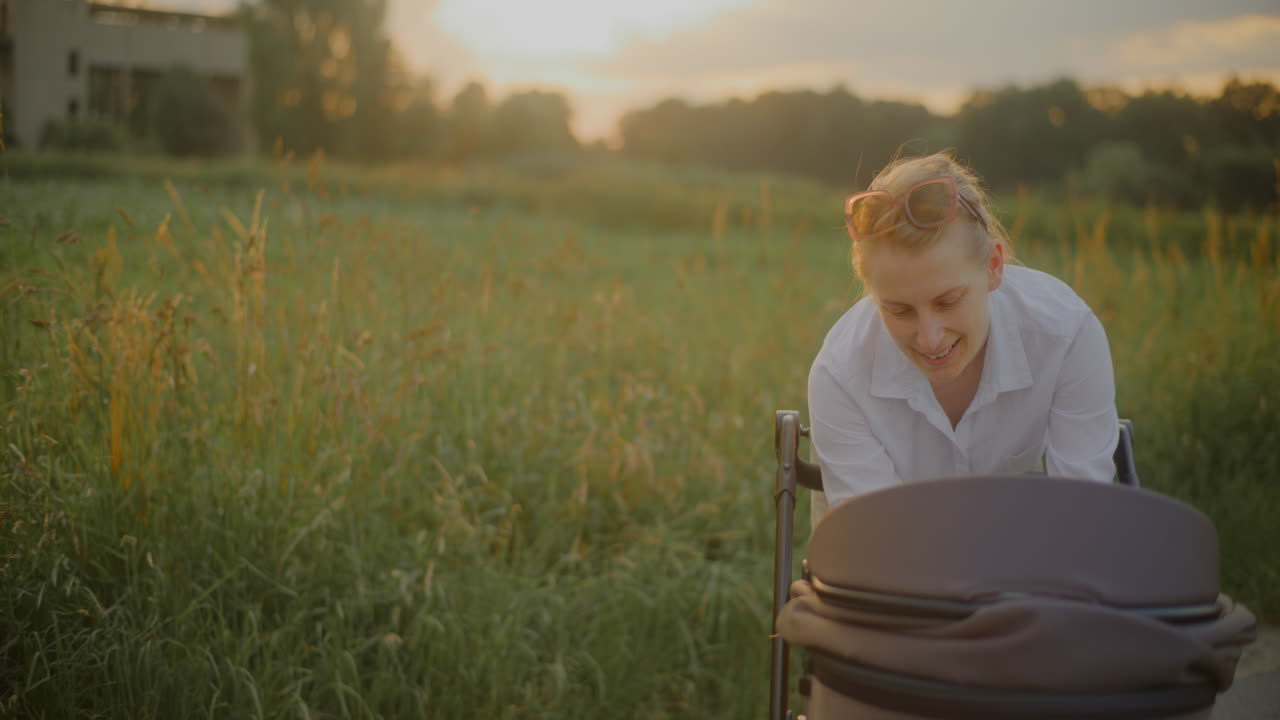 Mother Embracing Child in Stroller at Sunset