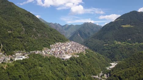 Antena-De-Un-Pequeño-Y-Hermoso-Pueblo-En-Una-Montaña-Verde-Y-Exuberante,-Premana,-Italia