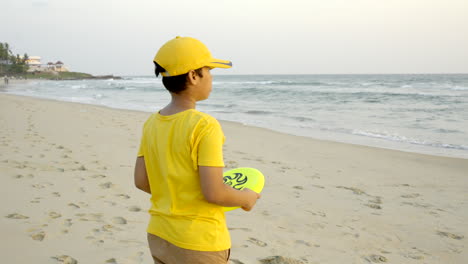 boys playing frisbee at the beach