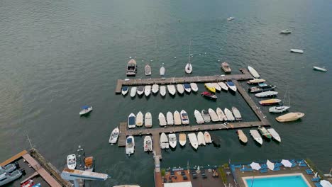 4k aerial drone video of boat docking in the marina on beautiful lake como, italy in the summer