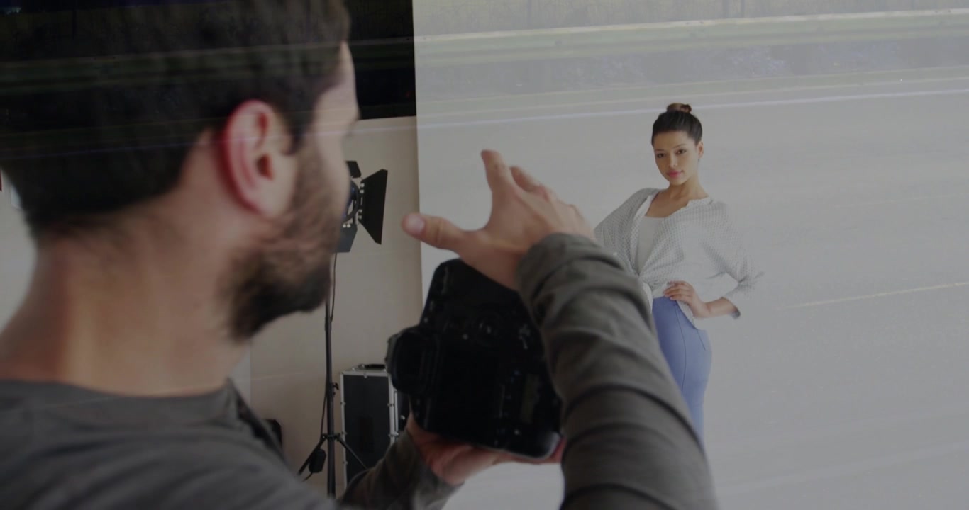 Photographer checking DSLR and framing, gesturing, model posing for fashion, streaks across frame