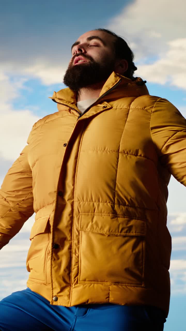 Bearded Man in Yellow Jacket Taking a Deep Breath Outdoors
