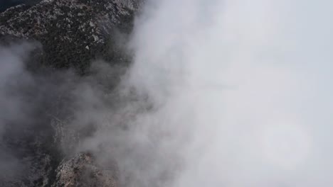 antena que pasa a través de las nubes para revelar el anfiteatro thermessos en la ladera