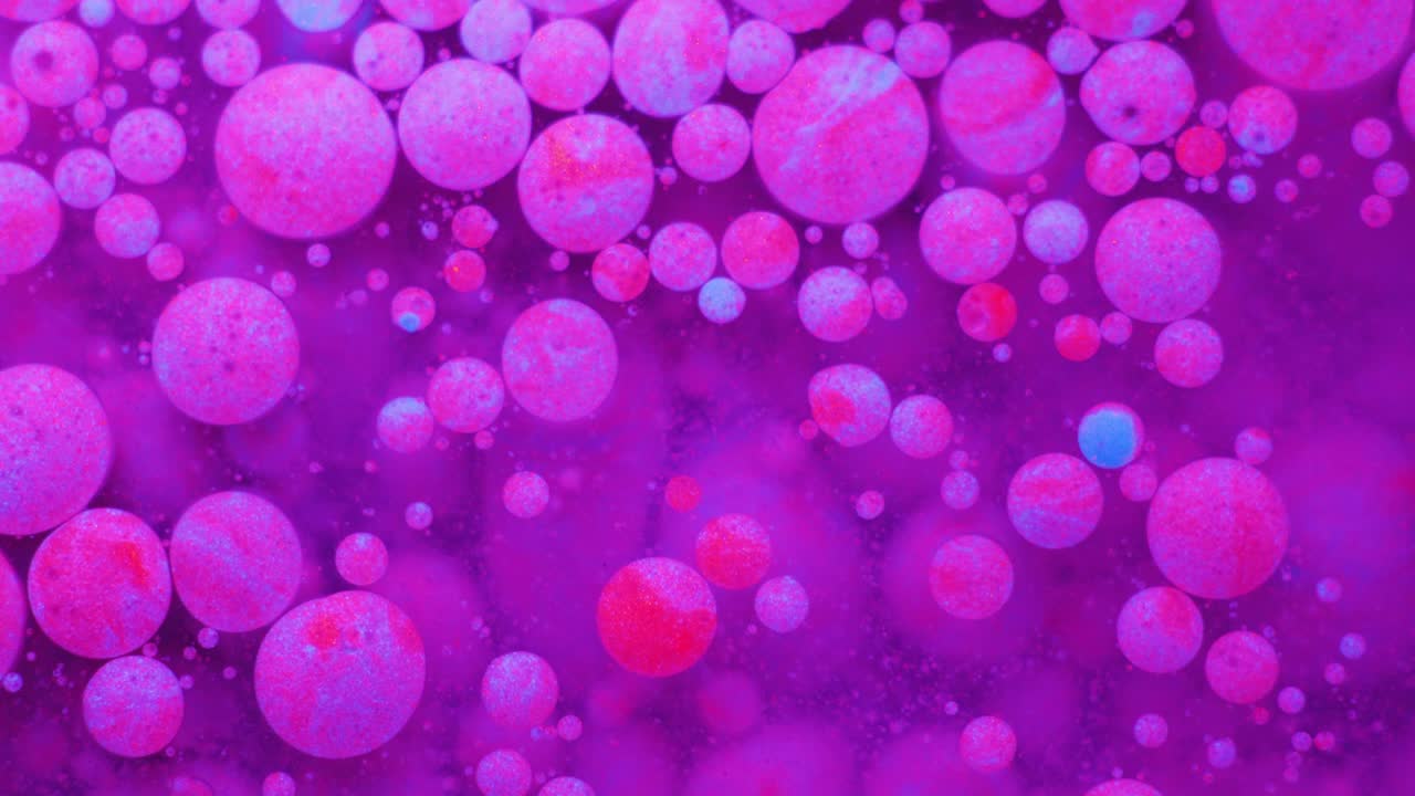 Slow Motion Bright Neon Color Bubbles Oil Beautiful Fluorescent Paint Sparkling Color Moving Multicolor Close up. Acrylic Neon Paint. Fantastic Surface. Abstract Colorful Transformation Gravitation.