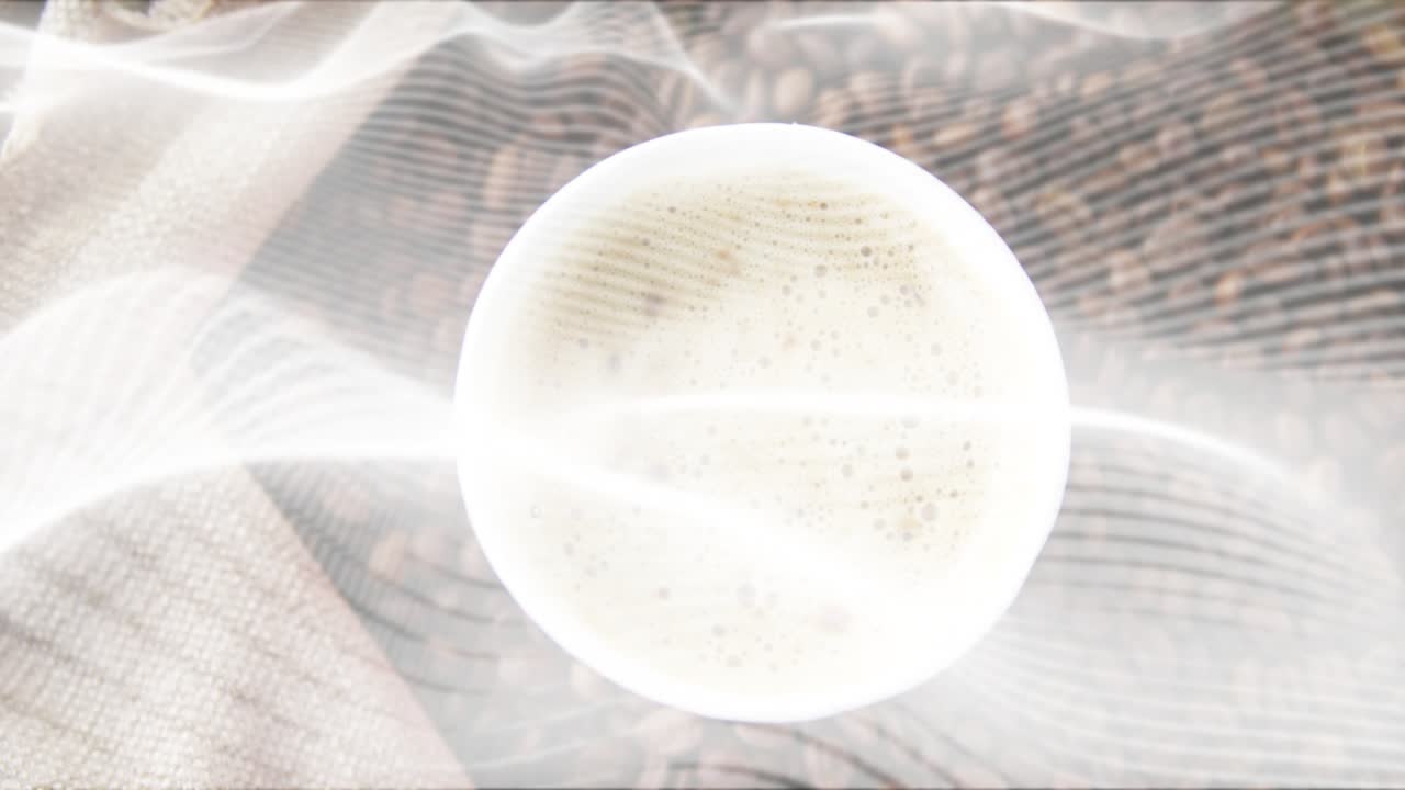 At start translucent drape drifting across striped cloth and beans for revealing white coffee cup