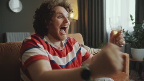 man celebrating a sports victory with beer
