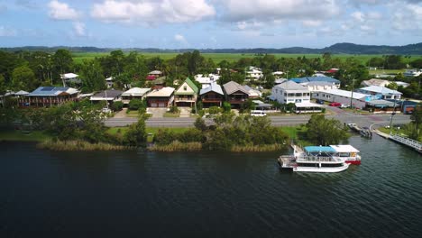 rising aerial view over tumbulgum with farm land in the background, along the tweed river, northern new south wales, australia