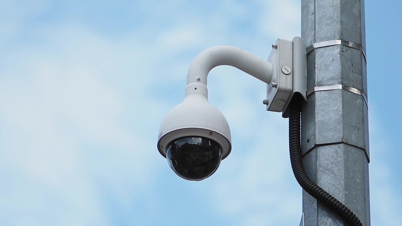Telecamera a cupola di sicurezza montata su palo metallico contro il cielo blu