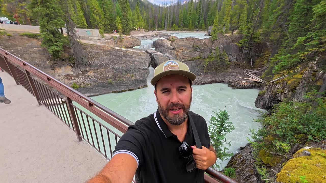 Homem em um cenário panorâmico ao ar livre com montanhas e rio