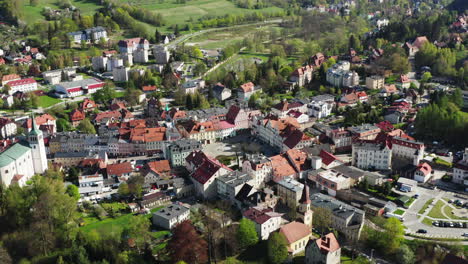 aerial view of market square in small old european town surrounded by green hills in sunny day, duszniki zdroj poland