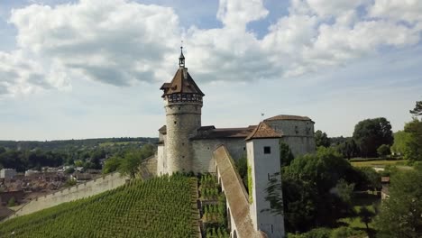 Dolly-Aéreo-En-La-Fortaleza-Y-Torre-Circular-Munot-En-Una-Colina-Verde-Que-Revela-El-Pintoresco-Pueblo-De-Schaffhausen,-Suiza