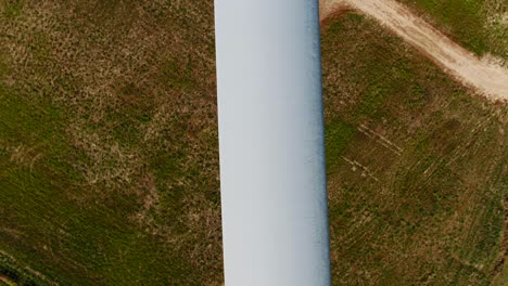 cuchilla de la hélice de la turbina eólica con inspección aérea de aviones no tripulados de primer plano y fondo de hierba