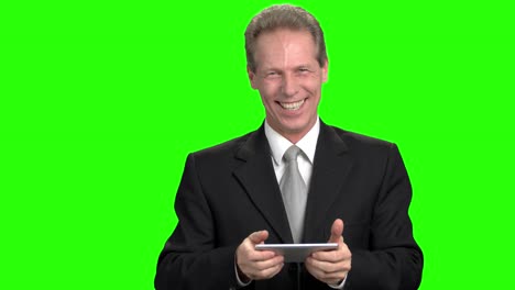 extremely cheerful business man playing mobile video games.