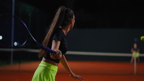 woman playing tennis at night