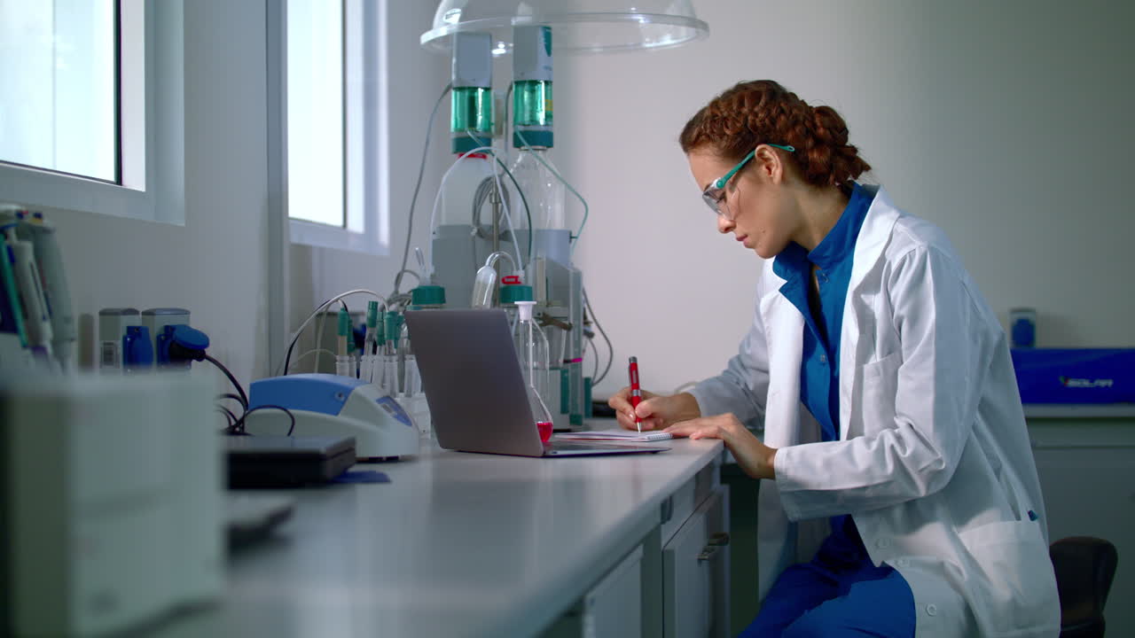 Researcher in lab. Young woman working in modern laboratory. Scientist research
