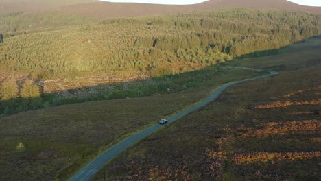 aerial view, follow shot, 4k, drone footage following a car driving on a mountain road