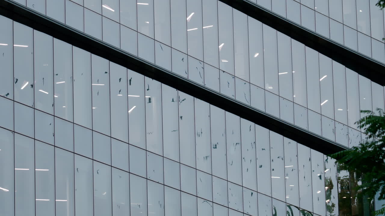 Architectural shot of a modern office building with reflective glass panels and geometric lines