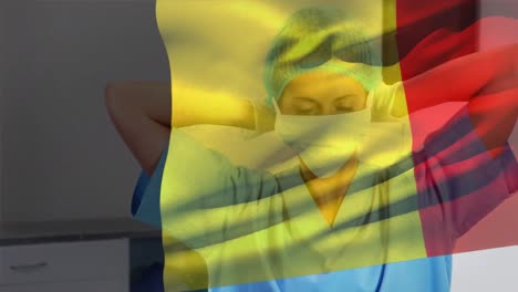 Animation-of-flag-of-belgium-over-caucasian-female-surgeon-with-face-mask