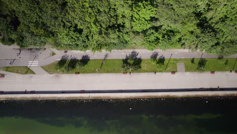 overhead drone shot of few people walking with their dogs and skateboarding along seaside boulevard during daytime in gdynia city, poland