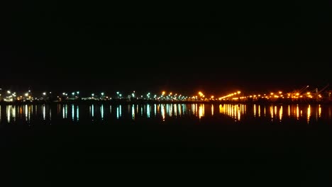 las olas se balancean suavemente mientras las luces del puerto se reflejan en la bahía