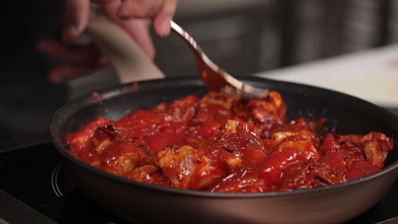 chef preparando un plato de cerdo en una sartén
