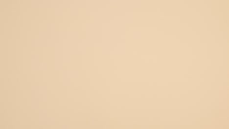 los productos de cuidado de la piel de belleza con toalla rosa pastel aparecen sobre un fondo beige.