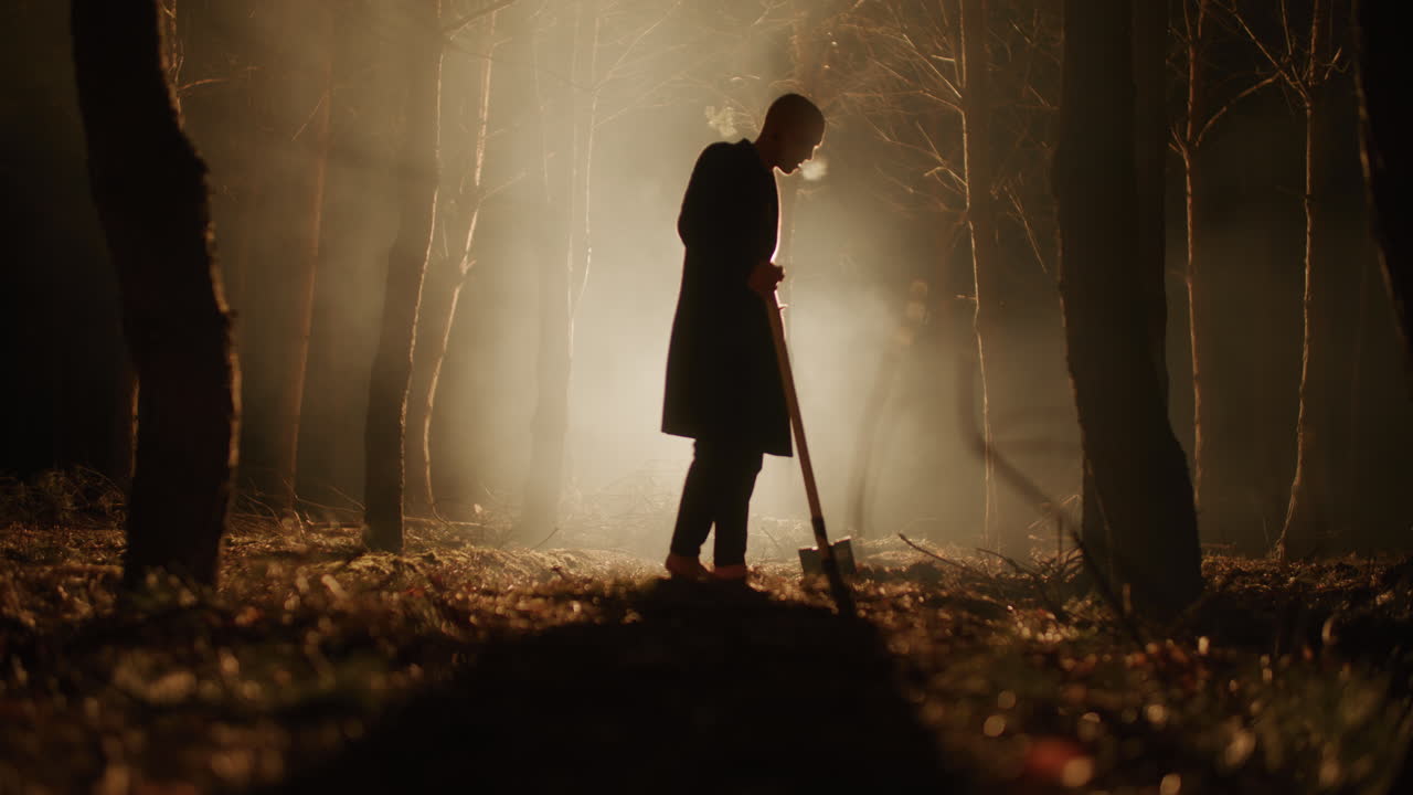 Silhouette of a Person in a Forest at Night