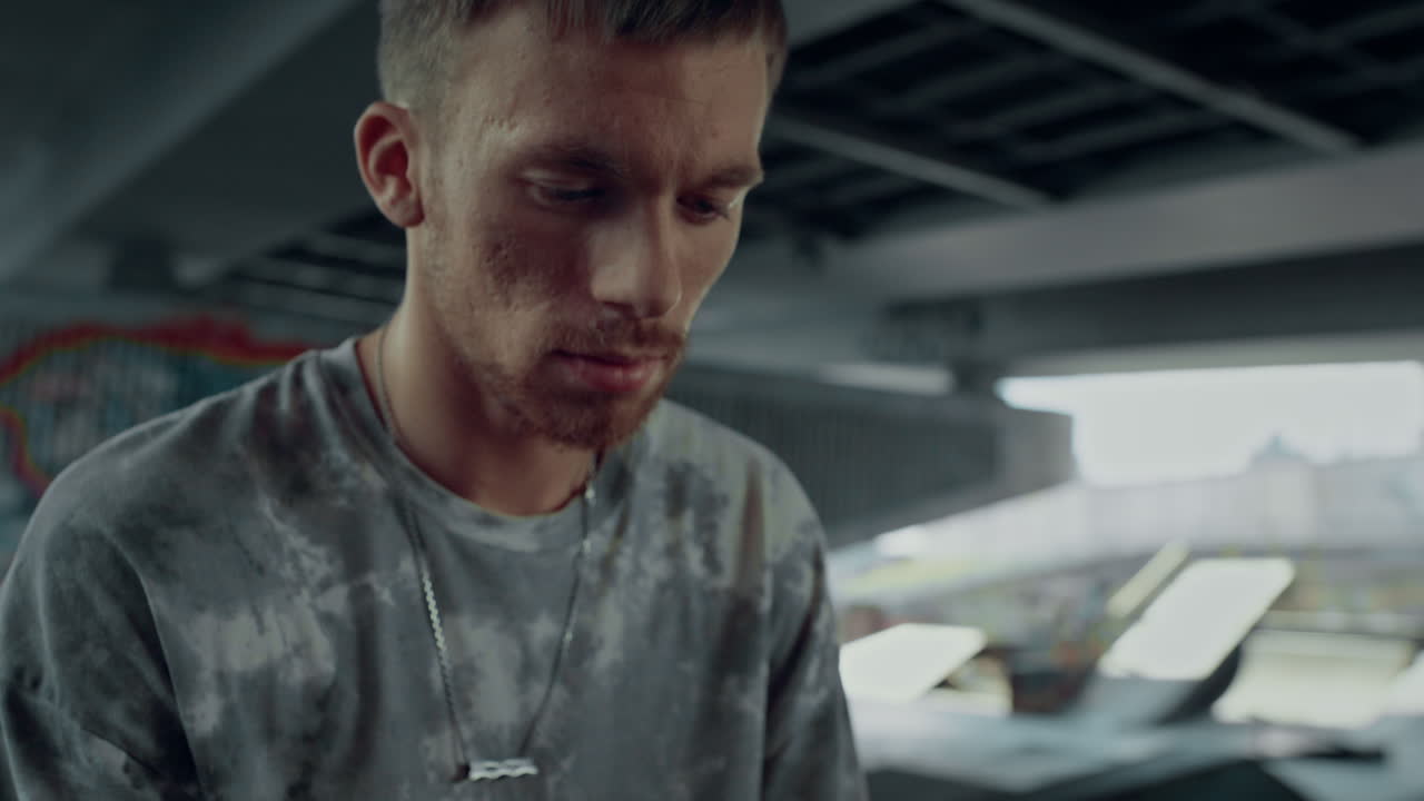 스케이트파크에서 휴대폰으로 웹을 서핑하는 젊은  ⁇ 스터.  ⁇ 드폰으로 채팅하는 남자.