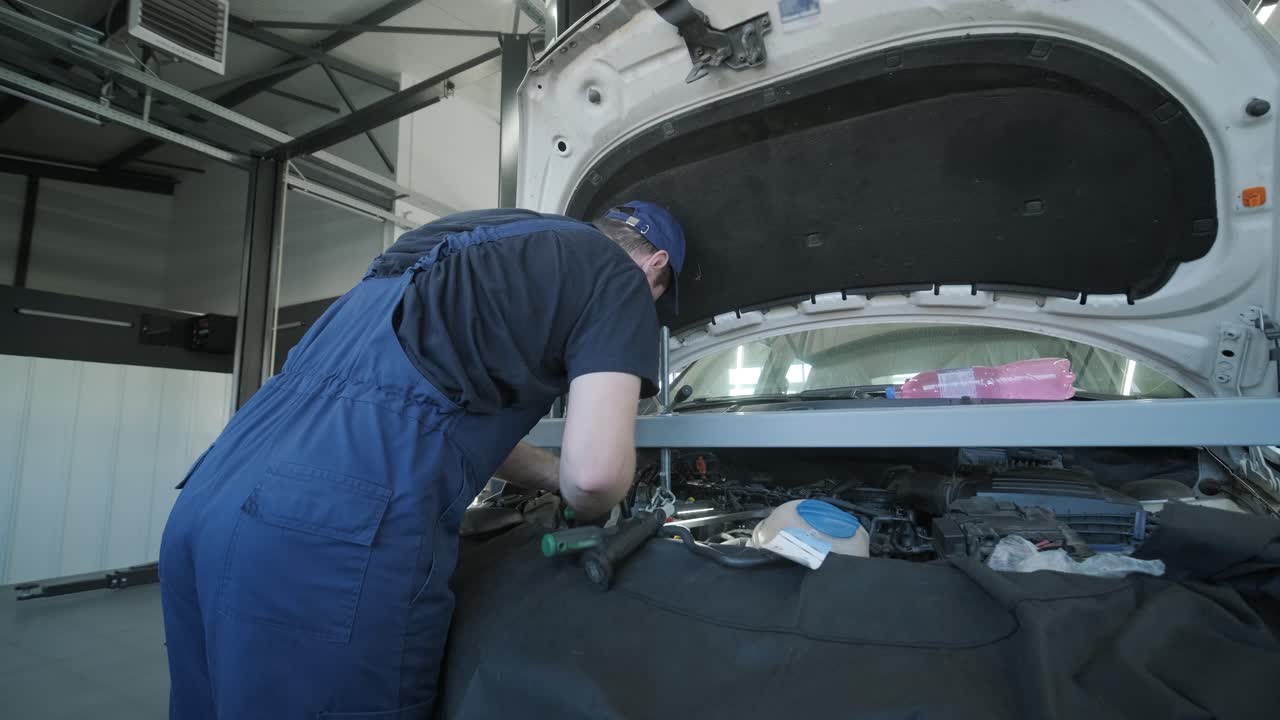 작업장에서 자동차 엔진을 검사하는 자동차 기계공