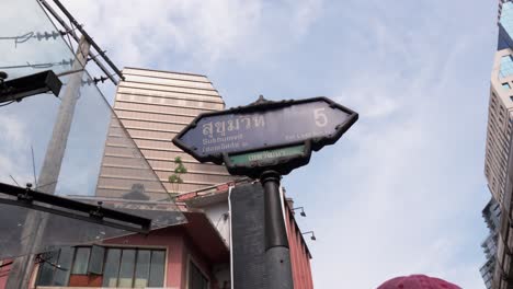 sukhumvit street name sign, dolly shot under clear blue sky, bangkok