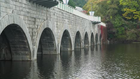 Scenic-Bridge-Over-Gwacheon-Lake-At-The-Seoul-Grand-Park-In-Gwacheon-City,-Gyeonggi-do,-South-Korea---Autumn-In-Seoul---side-view-shot