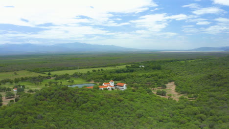 Aérea---Toma-épica-De-Una-Hacienda-En-Medio-De-Un-área-Boscosa,-Toma-Giratoria