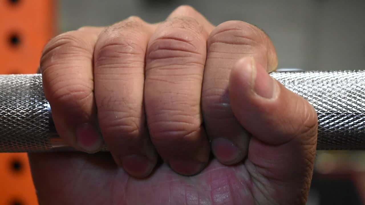 Close-up of a hand gripping a barbell
