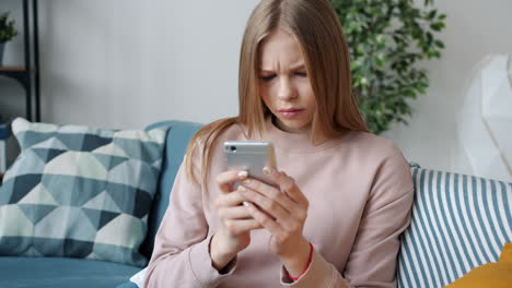 Teenager Sitting on a Sofa Texting on Smartphone