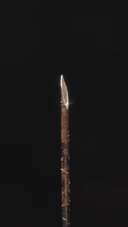 rusty needle of old medical syringe turning on black background. hypodermic tool used for injecting substances into body or extracting fluids macro