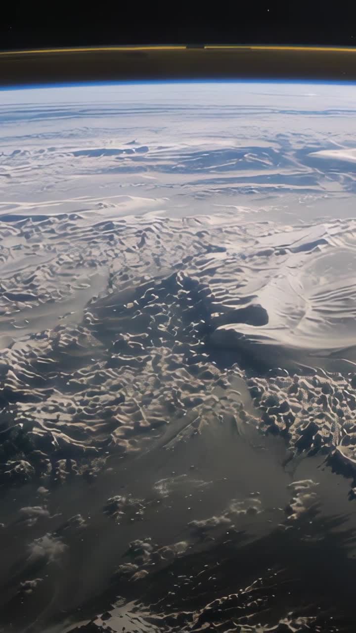 Vertical video: Opening camera panning across Earth horizon, showing limb glow and glacial valleys
