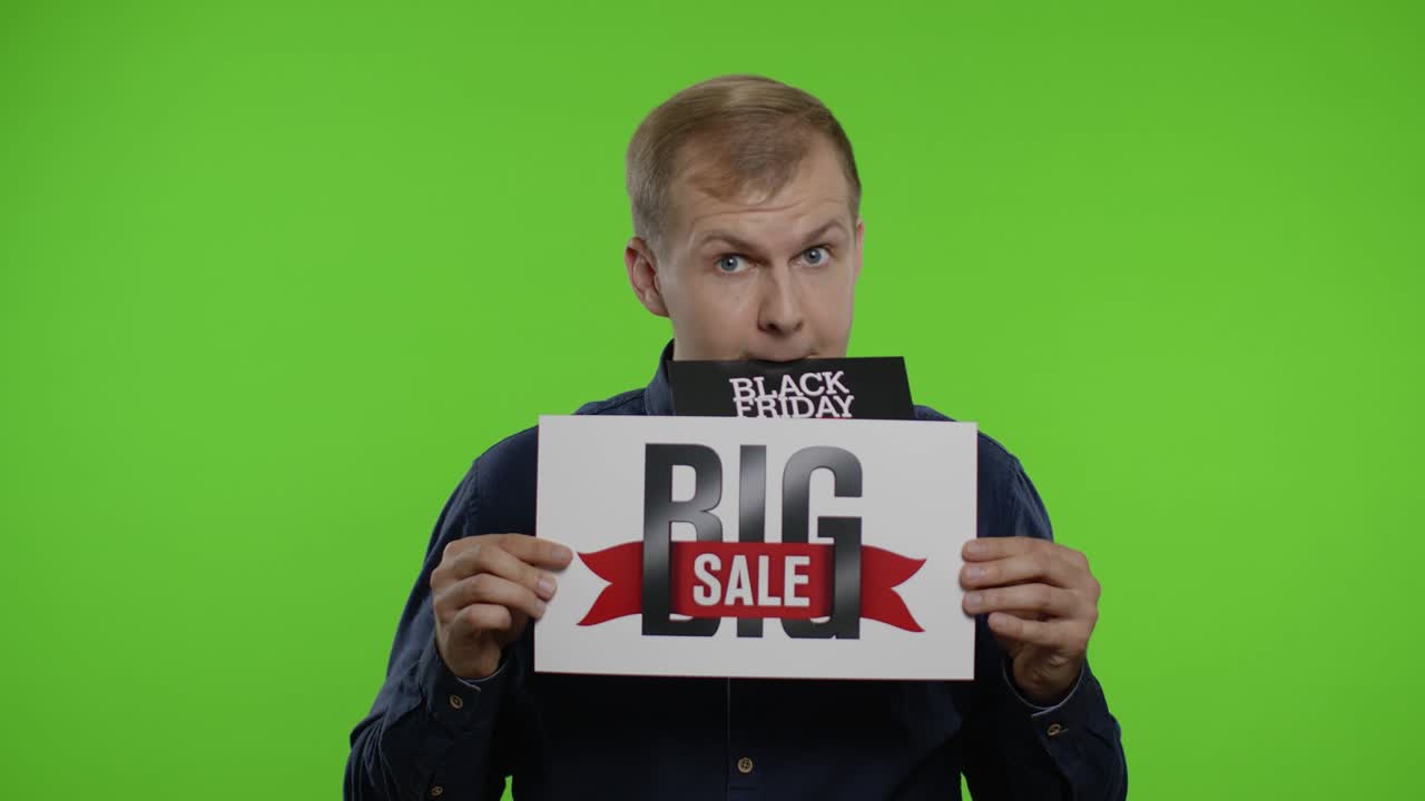 남자 쇼핑객은 그의 달에 블랙 프라이데이 거래 광고를 들고 큰 판매 문구를 보여줍니다.