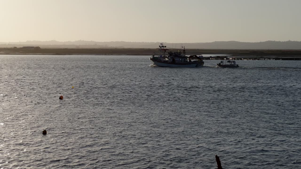 Fishing boats leaving and entering the harbor at sunset
