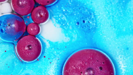 vibrant ink droplets expanding in water with a mix of pink and blue hues