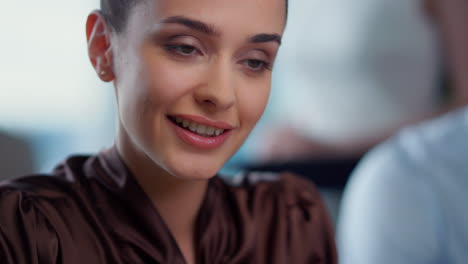 businesswoman looking down at workplace. smiling female worker posing at camera