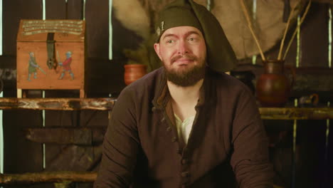 happy barkeeper looks around in tavern. smiling dwarf inn attendant cleans counter controlling guests in medieval store. historic reconstruction club