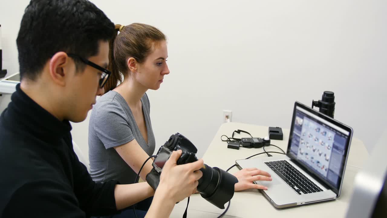 디지털 카메라로 찍은 사진을 검토하는 남성 사진작가