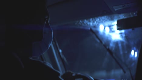 el joven con la máscara médica conduciendo en una carretera nocturna