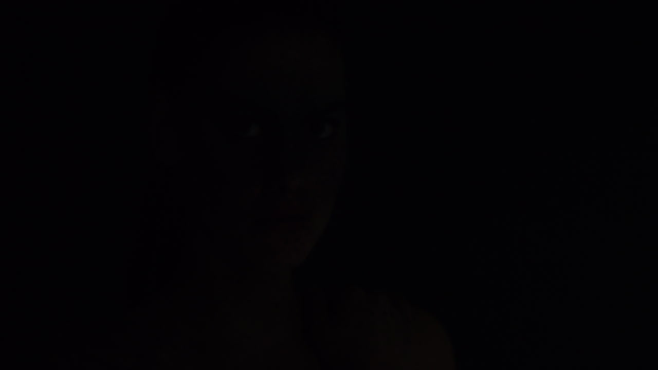 retrato de una mujer hermosa con maquillaje de pintura facial azul buscando arte corporal exótico en una artista femenina atractiva expresión creativa luz desvaneciéndose en un fondo oscuro