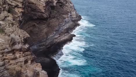 drone aerial cliffside hawaii waves on rocks