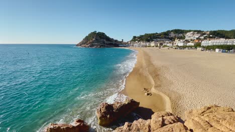 tossa de mar bay seen from the castle to the beach with coarse sand and turquoise blue sea water old walled medieval fishing village mediterranean sea