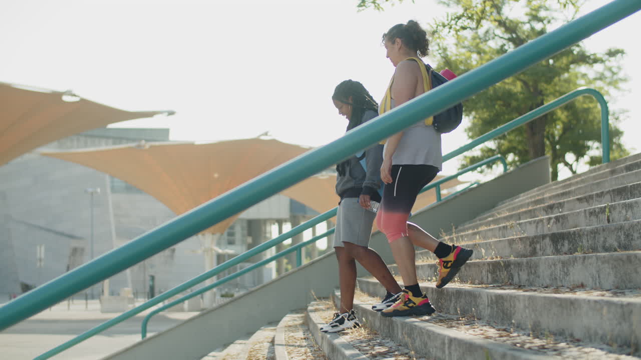 tiro largo de mujeres gordas bajando las escaleras del complejo deportivo